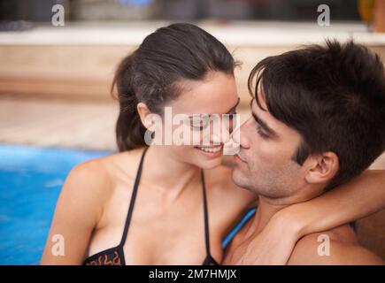 Riscaldamento durante il raffreddamento. una coppia attraente che si avvicina in una piscina. Foto Stock