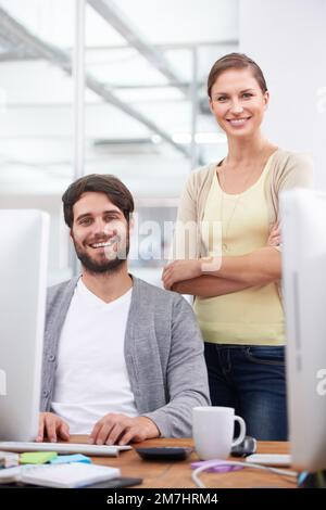 Che duo dinamico. Due giovani colleghi sorridono alla telecamera. Foto Stock