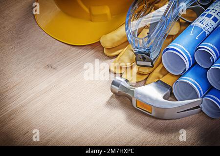 Composizione di utensili di costruzione per indumenti da lavoro di sicurezza su tavola di legno. Foto Stock