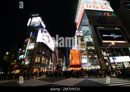Pedoni che attraversano verso il quartiere dei divertimenti di Kabukicho a Shinjuku, Tokyo, Giappone. Foto Stock