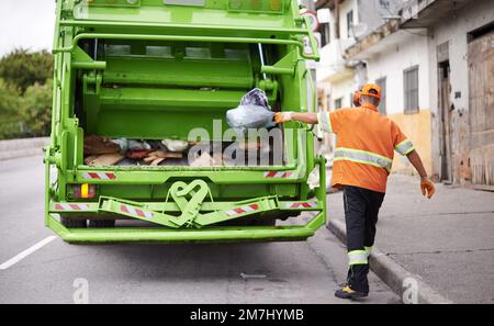 Giorno di raccolta dei rifiuti. un lavoratore impegnato nella raccolta dei rifiuti. Foto Stock