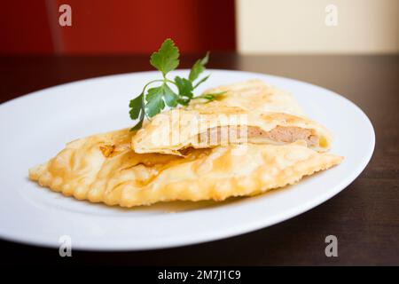 Un blini, o a volte blin, è una frittella russa e più ampiamente orientale europea che è tradizionalmente fatta da grano saraceno o farina di grano. Foto Stock