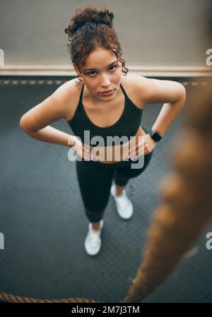 Arrampicata su corda, palestra e fitness di una donna pronta per le sfide sportive, allenamento completo del corpo e allenamento. Atleta femminile, ritratto e arrampicata Foto Stock