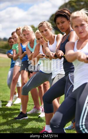 Il lavoro di squadra è la chiave della vittoria. una squadra di tira-of-guerra ragazze allenarsi all'aperto. Foto Stock