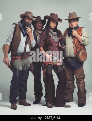 Significhi come i serpenti di battito e pronto per colpire. Una banda di fuorilegge in piedi isolati sul grigio, pur guardando duro. Foto Stock