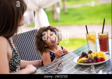 Mamma e figlia che hanno frutti e che si presentano felici Foto Stock