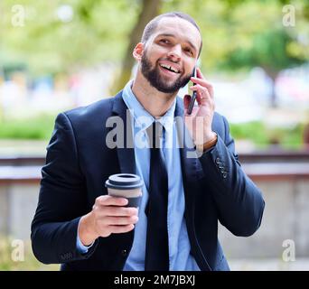 Uomo d'affari, telefono e parco cittadino con caffè per energia, conversazione o relax in pausa dagli alberi. Nero aziendale, smartphone o. Foto Stock