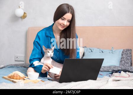 Bella donna che utilizza il notebook per acquistare qualcosa online Foto Stock