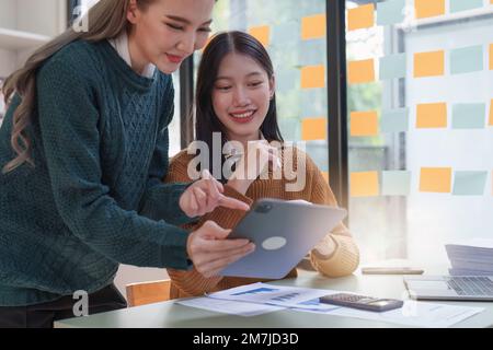 Incontro del consulente asiatico per le imprese per discutere e analizzare la situazione del rapporto finanziario nella sala riunioni. Fondi investimenti e contabilità Foto Stock