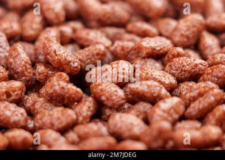 Fiocchi di riso al cioccolato con puffed di cereali. Colazione croccante con cioccolata. Macro Foto Stock