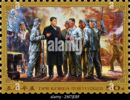 2022 francobollo per la Corea del Nord. 110th° anniversario di compleanno. Kim il-Sung parlando con i lavoratori dell'acciaio. Pittura Foto Stock