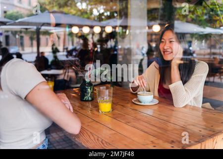 le coppie di donne hanno un appuntamento in una caffetteria Foto Stock
