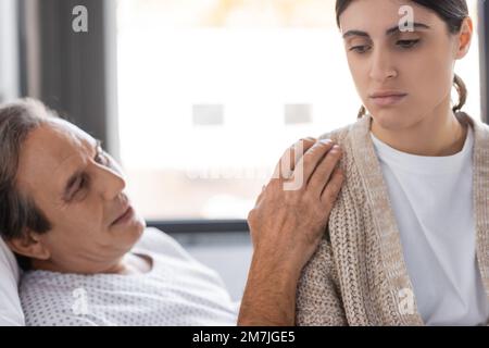 Offuscata paziente anziano calmante turbato figlia in reparto di ospedale, immagine di scorta Foto Stock
