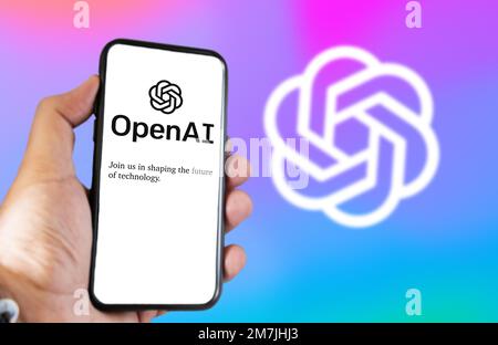 San Francisco US, 2022 dicembre: Una mano che tiene un telefono con il sito web OpenAI sullo schermo. Sfondo colorato con logo sfocato. OpenAI è un non profi Foto Stock