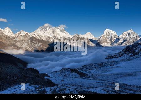 Vista sul monte Everest dal passo di Renjo la. Valle di montagna mozzafiato piena di nuvole ricci. La spettacolare vetta innevata dell'Everest sorge sopra il fiume di nube Foto Stock