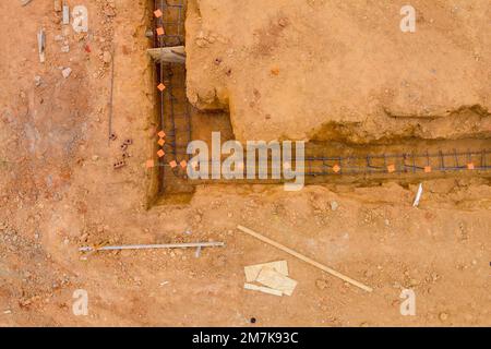 Esecuzione di lavori di messa in trincea dell'acciaio per la fondazione di case in cantiere Foto Stock