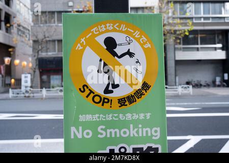 Tokyo, Giappone. 3rd Jan, 2023. Un cartello No Smoking sulla strada nel centro di Tokyo. Camminare mentre fumare è illegale in città e fumare in pubblico può essere condotto solo in determinate aree della strada, tuttavia fumare all'interno di bar e ristoranti è legale. Nihombashi è un quartiere nel centro di Tokyo, noto per il suo significato storico e la sua cultura tradizionale. Un tempo era il centro commerciale del Giappone ed è ancora sede di molti prestigiosi grandi magazzini, boutique di lusso e negozi di lunga data. Il quartiere è sede di molti artigiani e mercanti giapponesi tradizionali ed è un importante finan Foto Stock