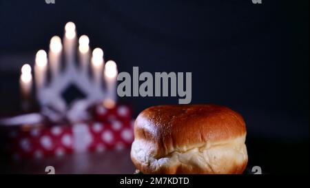 Una ciambella dolce cosparsa di zucchero in polvere per la vacanza ebraica di Hanukkah a casa. Primo piano Foto Stock