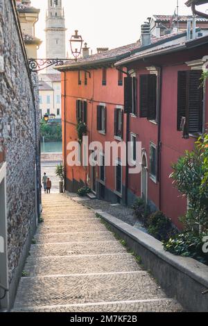 Due persone su una strada ripida tra gli edifici Foto Stock