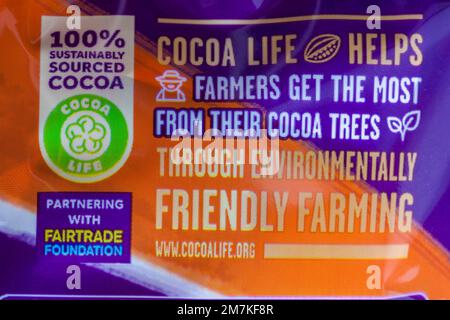 Il 100% reperisce in modo sostenibile informazioni sul Cocoalife di cacao sul pacchetto di Cadbury Dairy Milk Orange Foto Stock