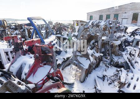 Le auto smontate su un autolavamento sono in vendita per i pezzi di ricambio. Una pila di parasoli e paraurti. Il commercio di parti di ricambio usate è un commercio comune nello sviluppo Foto Stock