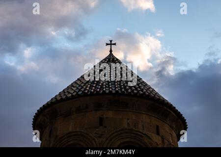 Campanile del Monastero gelati (campanile) silhouette scura contro il cielo nuvoloso blu, vista simmetrica con tetto in tegole verdi e croce sulla sommità. Foto Stock