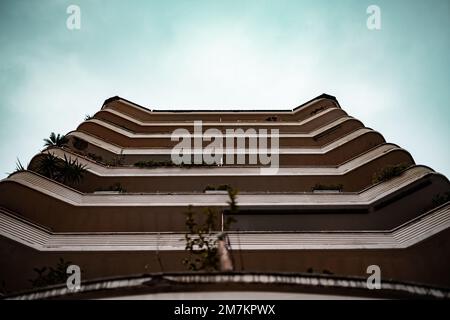 Un basso angolo di un alto edificio sotto un cielo blu Foto Stock