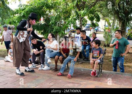 Clown intrattiene i bambini nella piazza principale di Tizimin, Yucatan, Messico Foto Stock