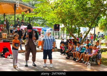 Clown intrattiene i bambini nella piazza principale di Tizimin, Yucatan, Messico Foto Stock