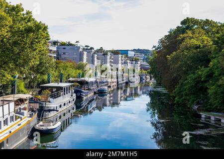 Issy-les-Moulineaux (zona di Parigi): Il fiume Senna lungo il parco parc de l'Ile Saint-Germain con chiatte abitate ormeggiate lungo la passerella e costruire Foto Stock