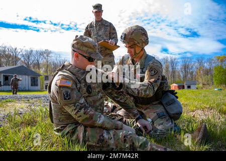 STATI UNITI Jordon Robbins, un ingegnere di costruzione orizzontale assegnato alla 185th Engineer Support Company, Maine Army National Guard, applica un laccio di applicazione di combattimento a un incidente simulato a Stones Ranch Military Reservation, East Lyme, Connecticut, 10 maggio 2022. Ogni concorrente doveva identificare la ferita simulata, applicare le misure di trattamento appropriate per quella ferita e poi doveva radio in una richiesta MEDEVAC (evacuazione medica) a nove linee. Foto Stock