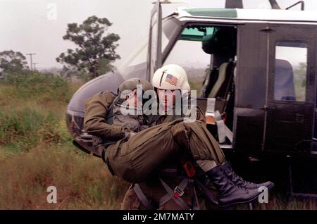 SPEC. 5 Harry Vercovic del distaccamento medico 68th, 25th Divisione di fanteria, rimuove IL CHIEF Warrant Officer Bill Kerr, un pilota di elicottero con la 347th Aviation Co., dal sito di incidente simulato di un elicottero UH-1 Iroquois. Partecipano a un esercizio sulla zona est delle caserme di Schofield. Stato: Hawaii (HI) Paese: Stati Uniti d'America (USA) Foto Stock