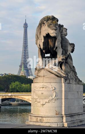 La Torre Eiffel si trova dietro una scultura di leone di Jules Dalou al ponte Pont Alexandre III che attraversa il fiume Senna a Parigi. Foto Stock