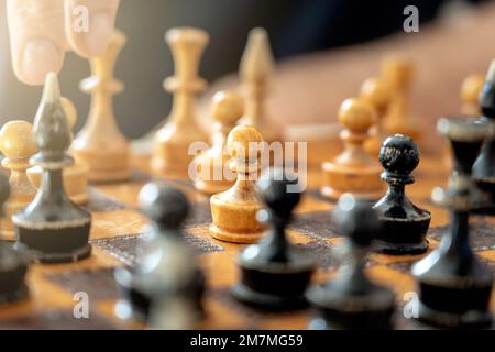pawn con altre figure sulla vecchia scacchiera vintage . Foto Stock