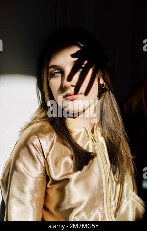 La ragazza si siede nella porta e noi abbiamo illuminato dal sole in arrivo Foto Stock