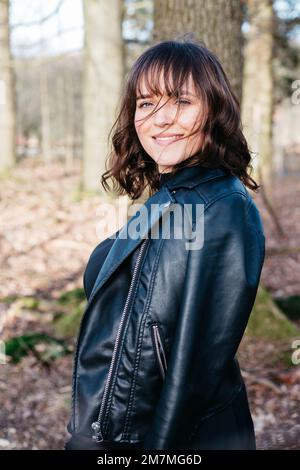 Felice giovane donna sorridente nella foresta Foto Stock