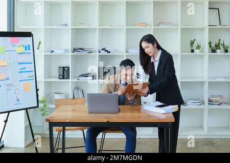 Gli analisti finanziari analizzano i rapporti di affari sui progetti di investimento pianificati durante le discussioni di riunione corporative mostrano il lavoro di squadra riuscito con Foto Stock