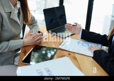 Gli analisti finanziari analizzano i rapporti di affari sui progetti di investimento pianificati durante le discussioni di riunione corporative mostrano il lavoro di squadra riuscito con Foto Stock