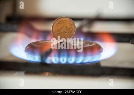 Un pezzo da 2 euro si trova sul piano cottura di una stufa a gas. Foto Stock