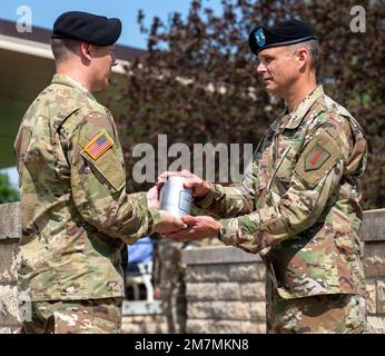 STATI UNITI L'esercito 2nd Lt. Gabriel Buckles (a sinistra), un ufficiale assegnato alla 1st Divisione di Fanteria, presenta gli Stati Uniti John V. Meyer III, la divisione fanteria del 1st e il generale comandante di Fort Riley, con un barattolo di artiglieria durante una cerimonia di cambio di divisione del comando del 11 maggio 2022, presso il campo di Cavallery Parade di Fort Riley. La presentazione del canestro simboleggia l’innalzamento della bandiera, quindi significa il primo giorno di Meyer come comandante generale della Divisione Fanteria 1st e di Fort Riley. Foto Stock