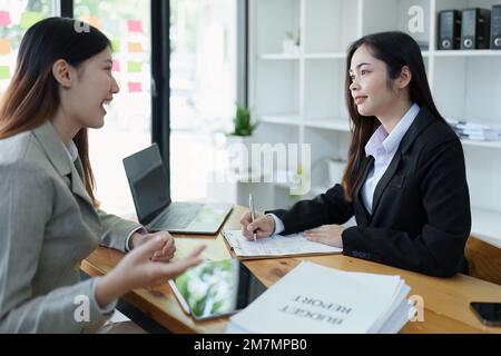 Gli analisti finanziari analizzano i rapporti di affari sui progetti di investimento pianificati durante le discussioni di riunione corporative mostrano il lavoro di squadra riuscito con Foto Stock