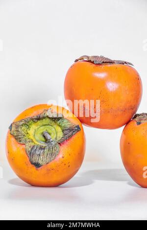 Diospyros kaki, Persimmon, frutta di stagione isolata su fondo bianco Foto Stock