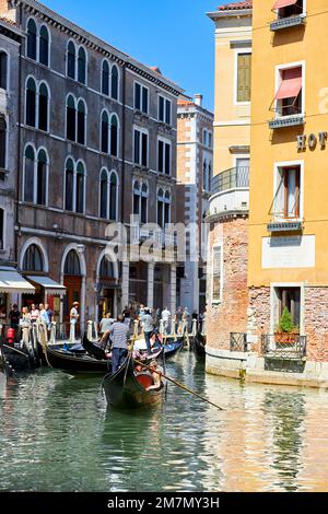 I gondolieri guidano i turisti attraverso la città lagunare di Venezia Foto Stock