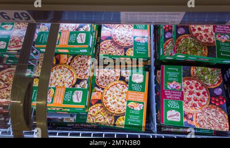 Italia - 08 gennaio 2023: pizze italiane surgelate precotte in cartone con foto di vari tipi di pizza in banco refrigerato in alto vi Foto Stock