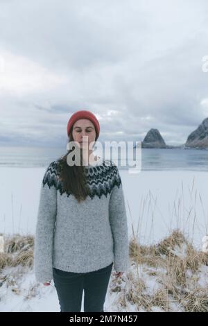 Giovane donna con cappuccio rosso sulla spiaggia Foto Stock