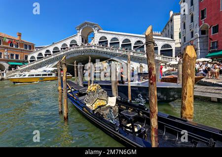 Il Ponte di Rialto di Venezia è uno dei punti di riferimento della città lagunare italiana, di fronte ad essa si trova una gondola ormeggiata Foto Stock