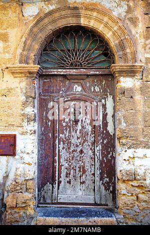 Porta d'ingresso intemperiata nel centro storico di Cefalù, Sicilia Foto Stock