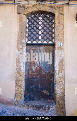 Porta d'ingresso intemperiata nel centro storico di Cefalù, Sicilia Foto Stock