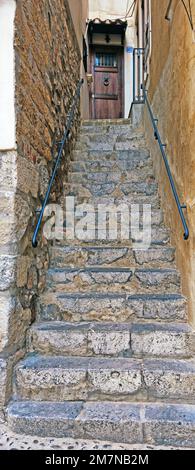 Ripide lunghe scale in pietra che portano alla porta d'ingresso, Cefalù, Sicilia Foto Stock