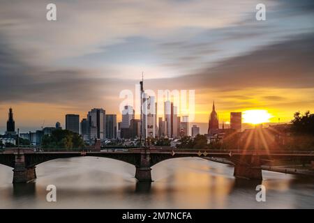 Lunga esposizione con vista sul fiume meno, sul ponte Ignatz Bubis e sullo skyline al tramonto. Foto retroilluminata di Francoforte sul meno, Assia, Germania Foto Stock